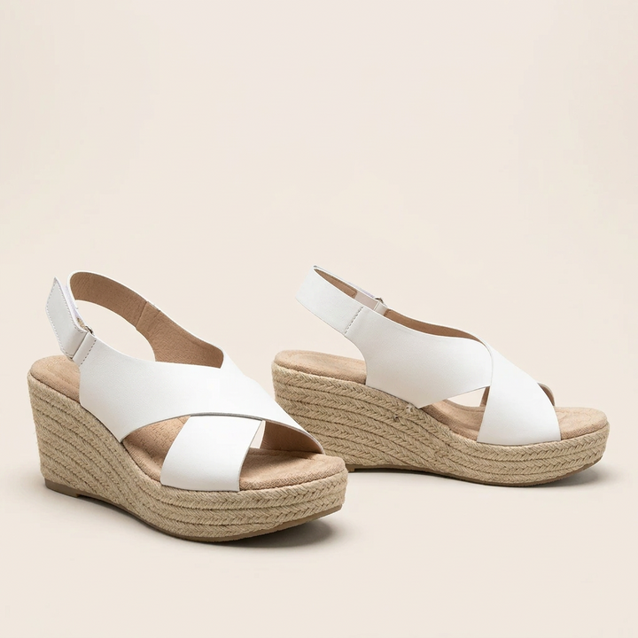 Pair of white crisscross wedge sandals with braided jute soles and padded footbeds on a cream background 15