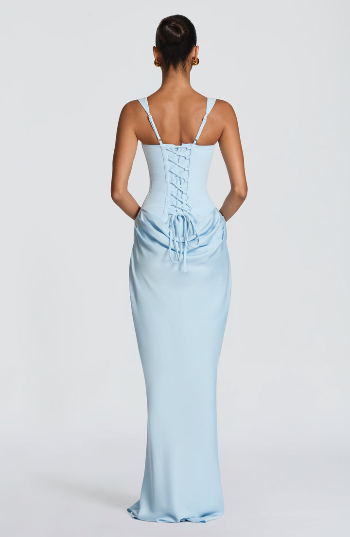 Back view in light blue showing the corset lace-up closure with trailing ties, adjustable straps and gathered drape. 28