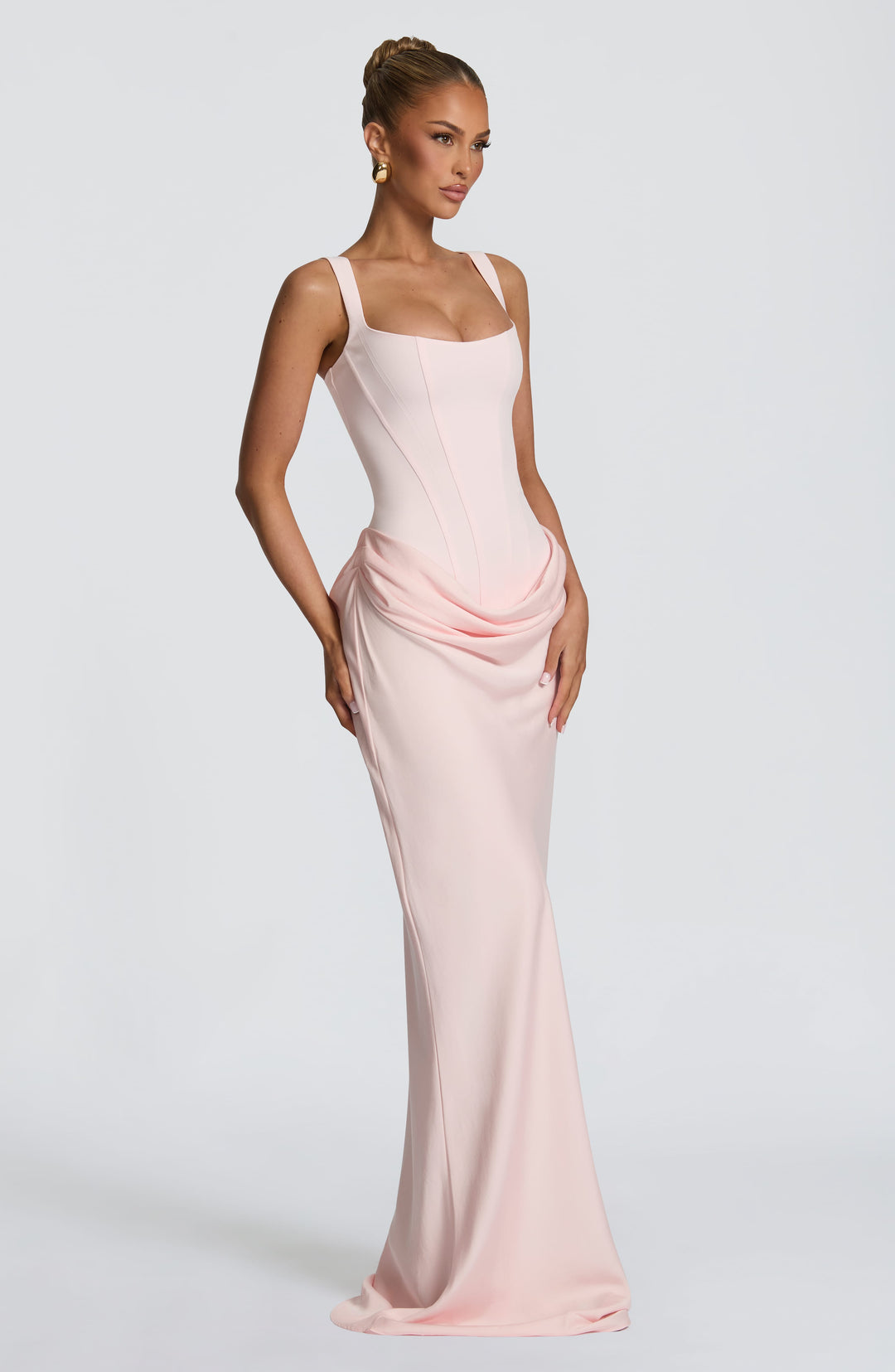Indy Bodycon Maxi Dress in light pink, three-quarter view with a corset bodice and scoop neckline.