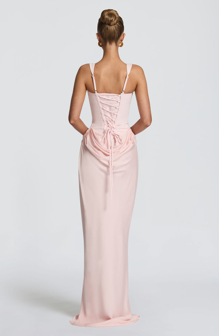 Indy Bodycon Maxi Dress in light pink, back view with a lace-up closure and draped fabric at the hips.