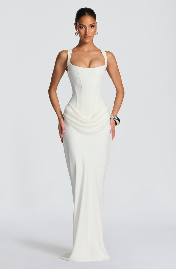 Indy Bodycon Maxi Dress in cream white with draped hips and a long skirt, front view.