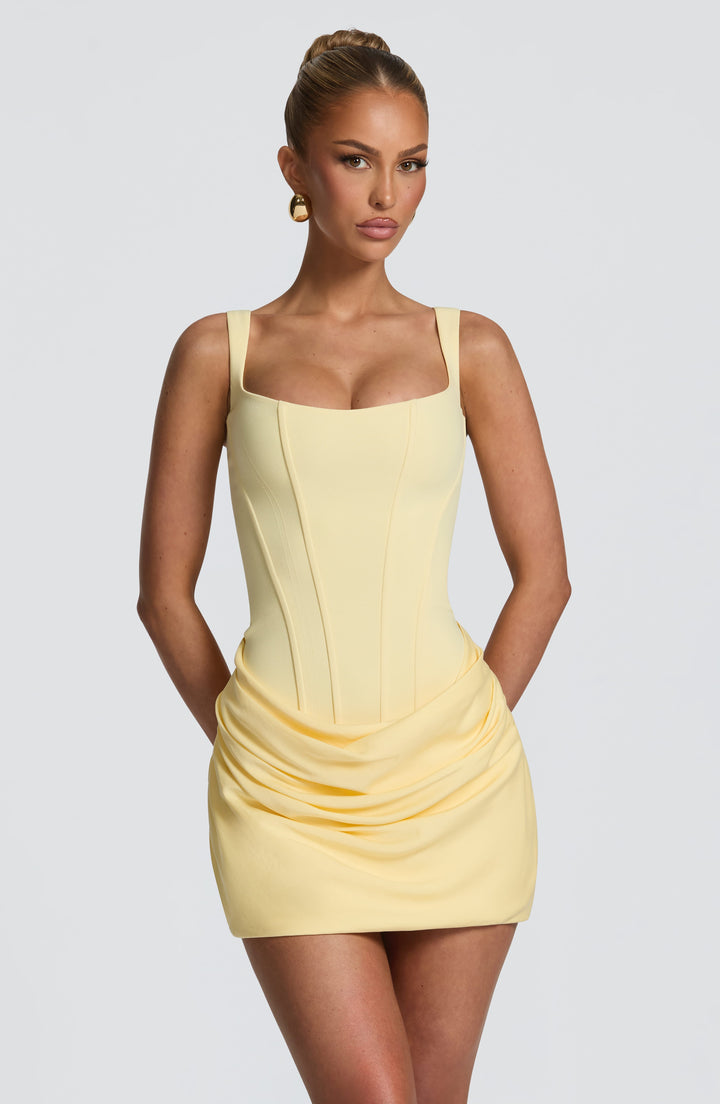 Close front view of the pale yellow corset-style dress with seamed bodice and draped skirt 22