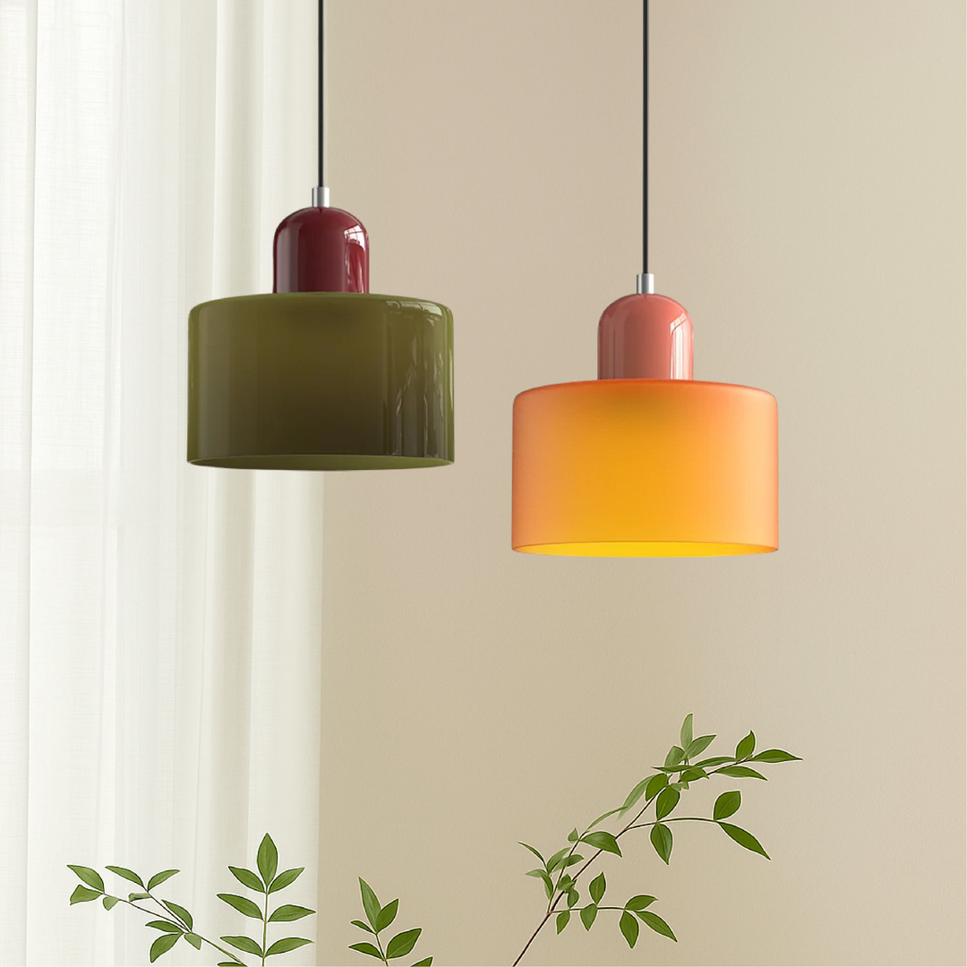 Two drum-shaped pendant lights, one olive green with a burgundy cap and one orange with a coral cap, hanging beside a sheer curtain. 1