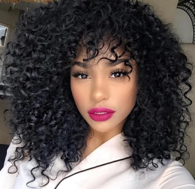Another view of voluminous black curls with bright pink lipstick and a white collared top.
