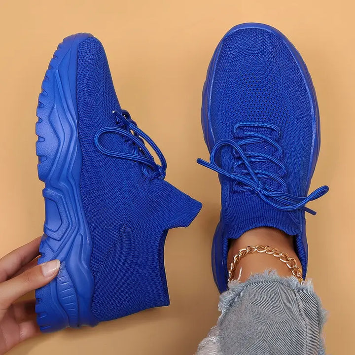 Solid royal blue knit sneakers with blue laces and chunky blue soles, top-down view.