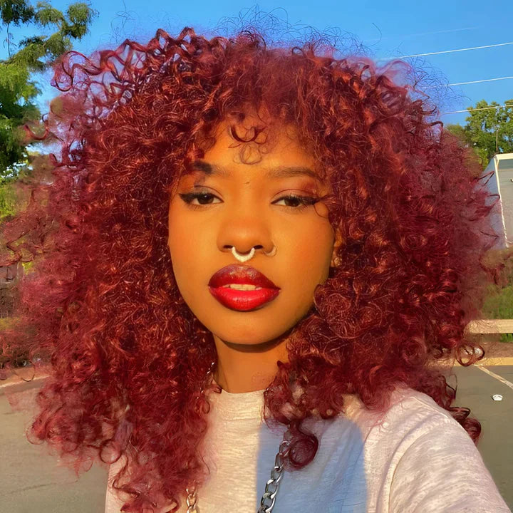 Another view of full curly hair in deep burgundy red with a nose ring.