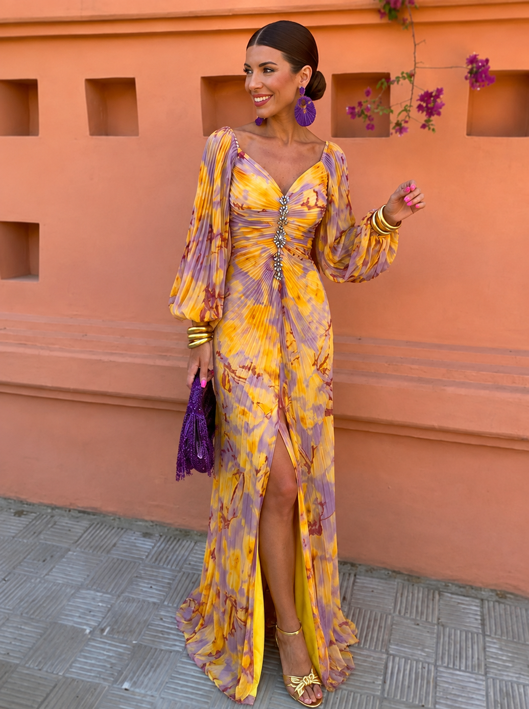 Yellow floral maxi dress with an off-shoulder neckline and pleated skirt on a smiling model.