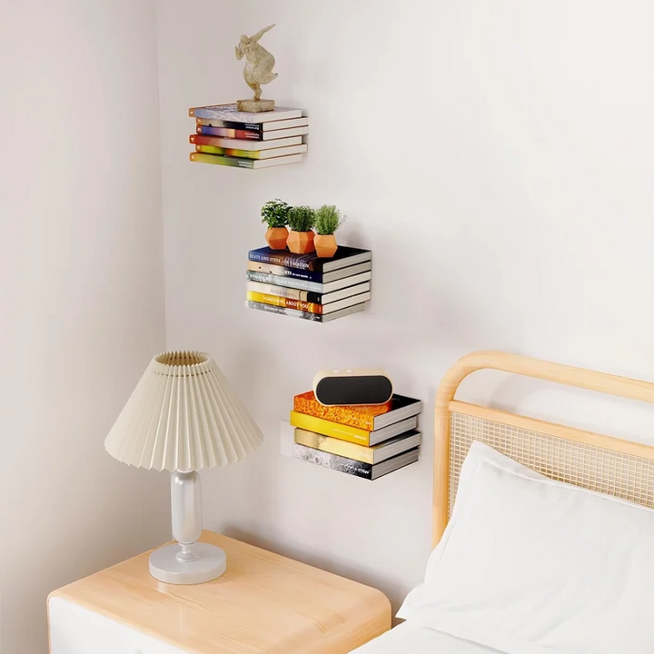 Black floating book shelf with books on a bedroom wall beside a bed