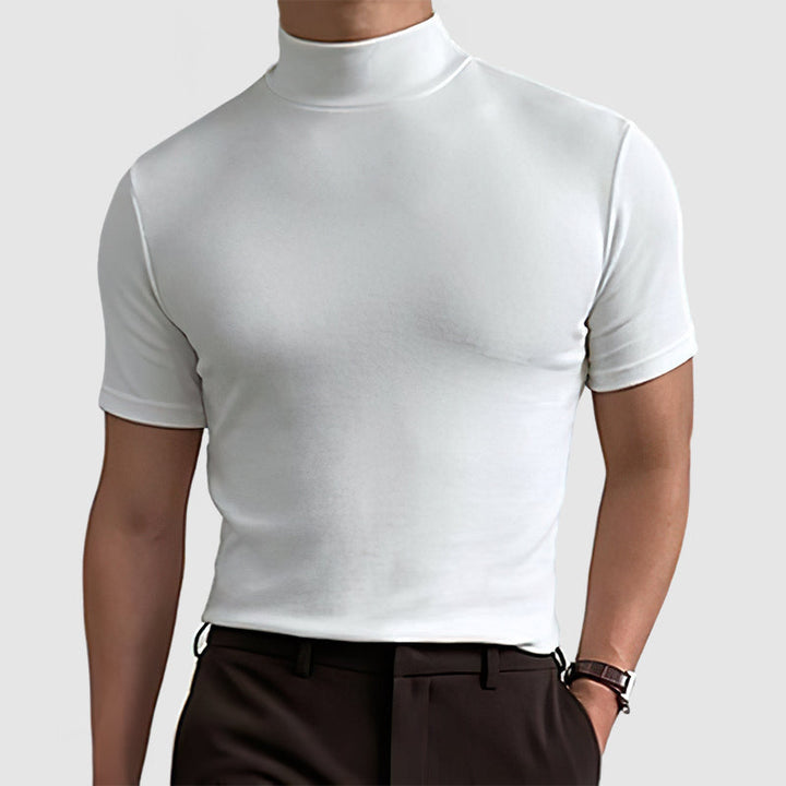 Model wearing the white mock-neck tee with dark brown trousers, front view showing the fitted torso and short sleeves.