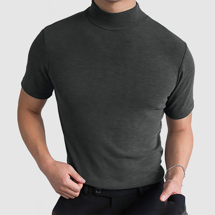 Model in the dark gray mock-neck tee with a hand on his belt and the other in a pocket, wearing a bracelet.