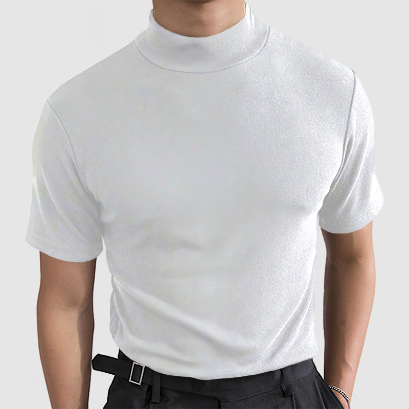 Model wearing the white short-sleeve mock-neck tee, front view, paired with black trousers and a belt.