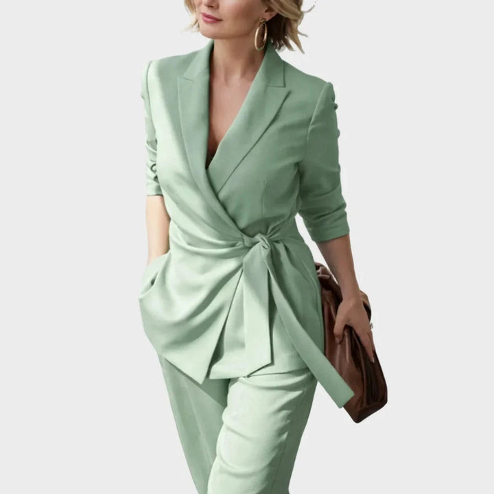 Women's matching blazer and pants set in sage green, detail of the tied waist belt.