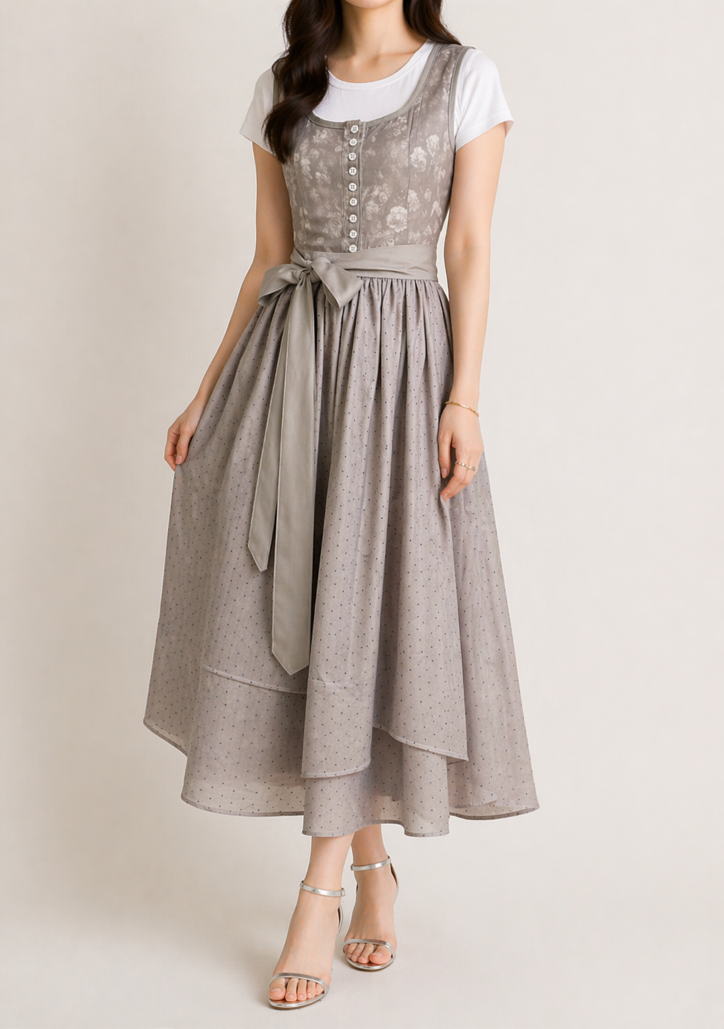 Grey dirndl dress full-length view with a gathered dotted skirt, layered hem and long waist bow.