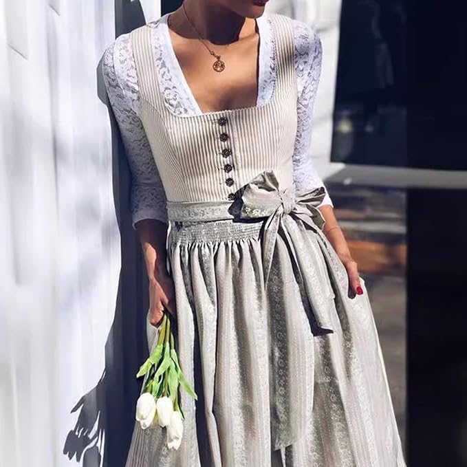 Another view of the dirndl worn over a lace blouse, holding white tulips, with the apron bow at the waist.
