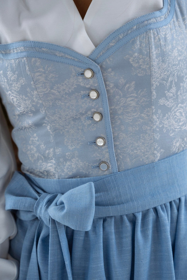 Women's blue floral dirndl set, detail of the bodice buttons and apron bow