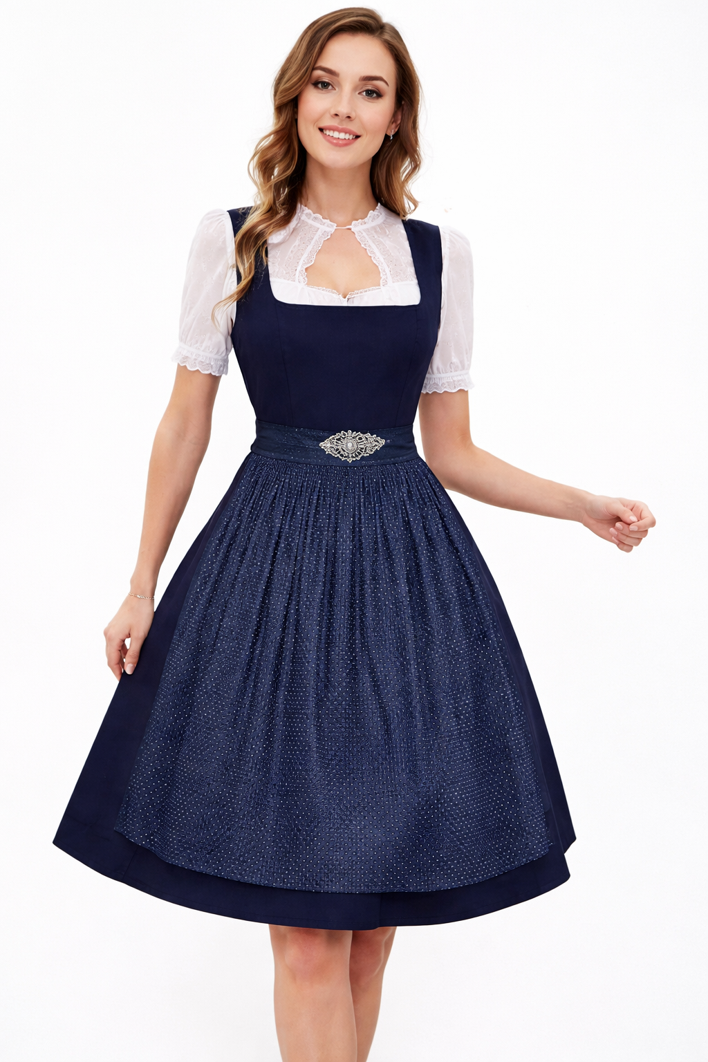 Smiling model wearing a navy dirndl with a dotted textured apron, silver brooch and white lace blouse with a keyhole neckline. 3