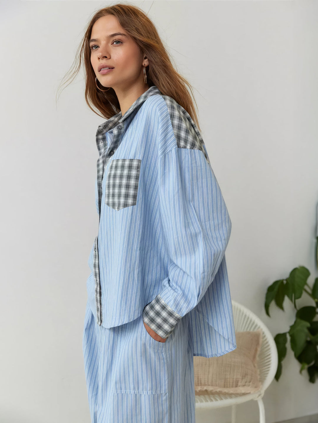 Blue striped pajama set with gray plaid trim, side view.