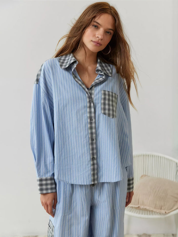 Blue striped pajama shirt with gray plaid collar, placket, pocket and cuffs, front view.