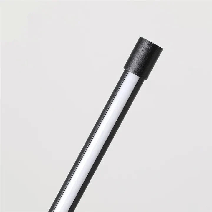 Close-up of the top of the lamp, showing the black end cap and the white diffuser strip of the light tube. 8