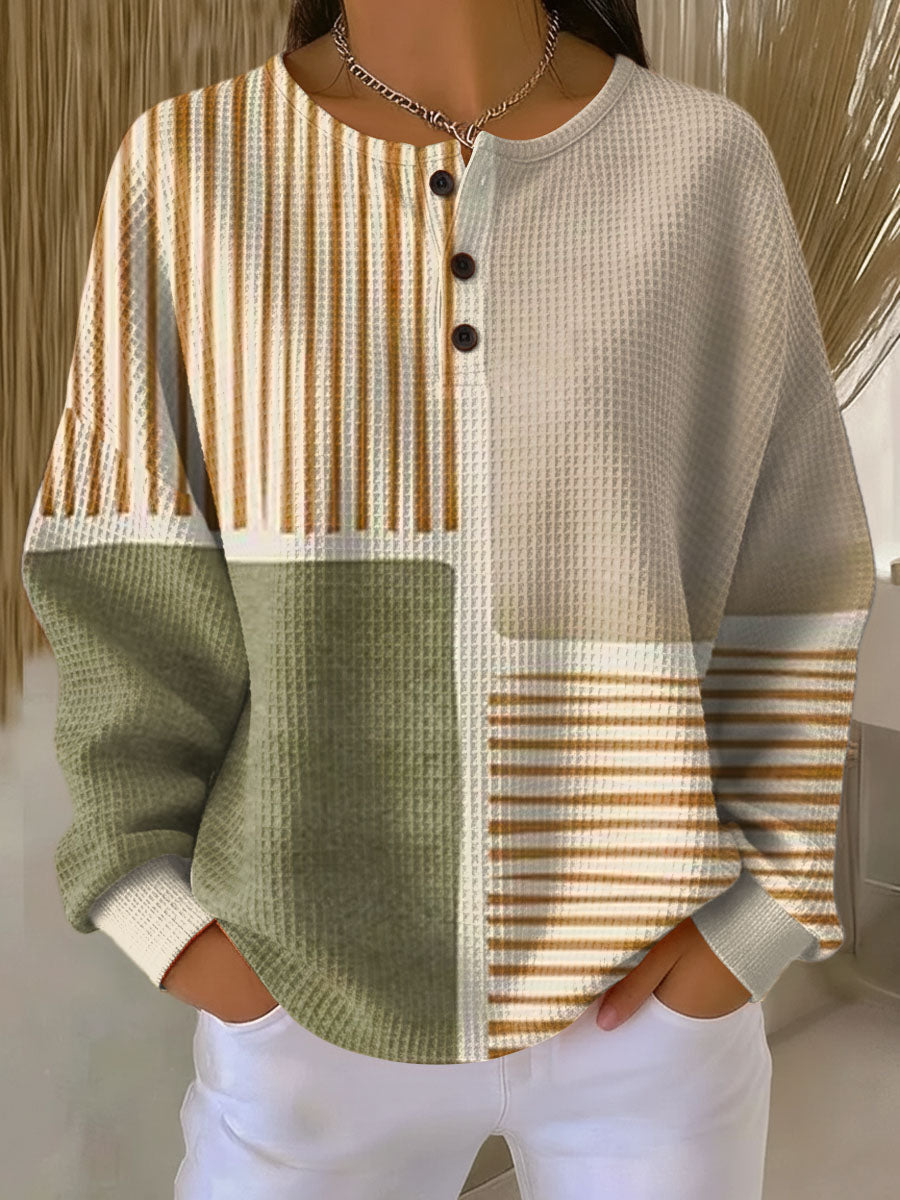 Waffle knit henley with olive green, cream and caramel striped color-block panels, worn with white pants 1