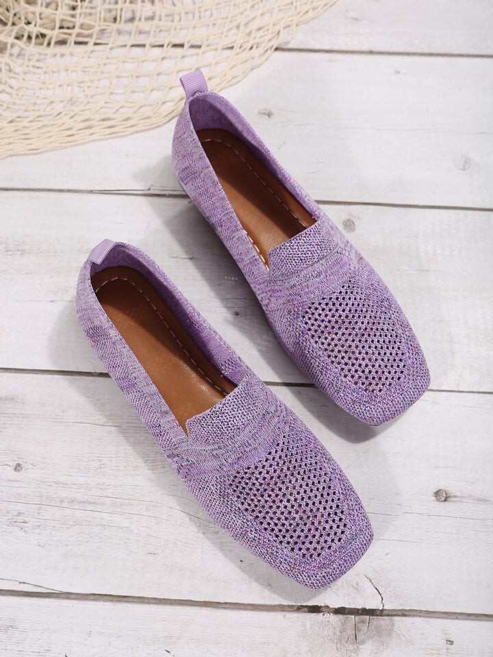 Pair of lilac knit slip-on flats with stitched brown insoles and mesh toes.