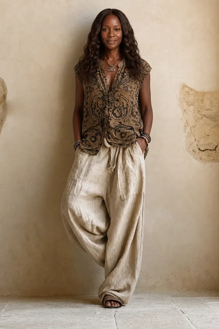 Model wearing only the sleeveless paisley-print top and drawstring wide-leg beige pants, hands in pockets, without the 2