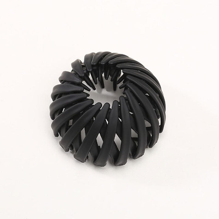 Twist-and-snap hair clip in black velvet shown from above.