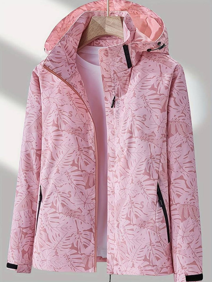 Pink leaf-print hooded jacket hanging open on a wooden hanger, showing a contrast zipper, black pocket zips and a mesh-lined hood. 4