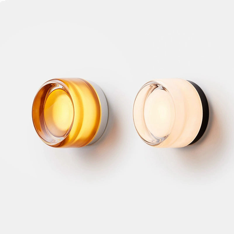 Two sconces side by side, one amber glass with a white base and one milky white glass with a black base. 4