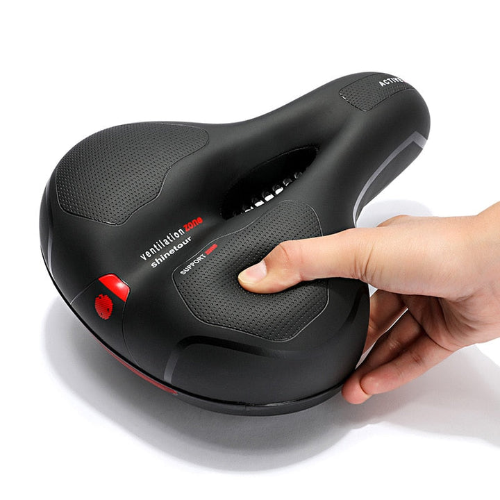 Close-up detail of a fingertip pressing the saddle's soft padding.
