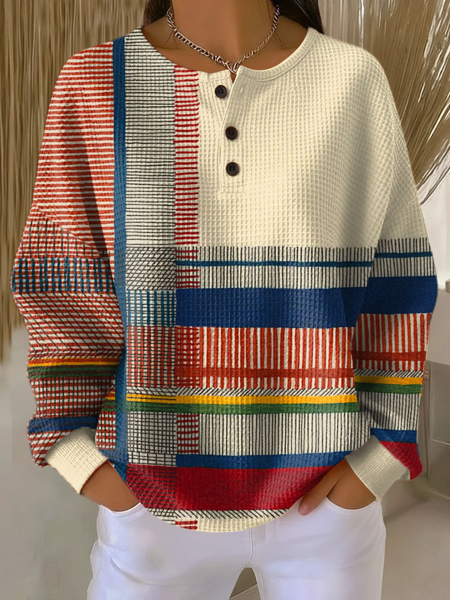 Cream waffle knit henley with red, blue, yellow and green striped patchwork sleeves and hem, worn by a model 6