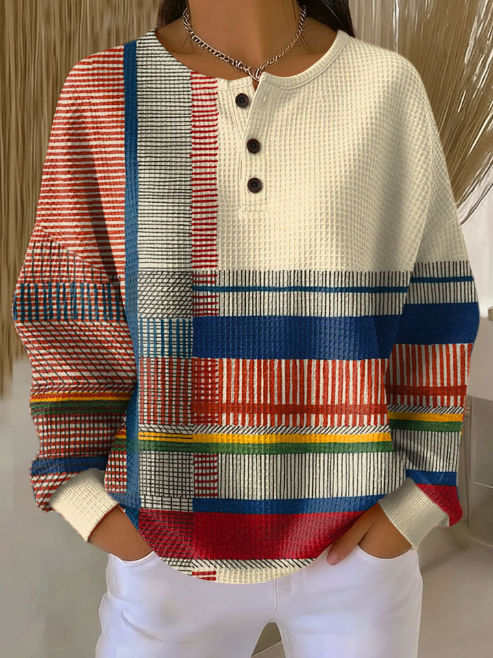 Cream waffle knit henley with red, blue, yellow and green striped patchwork sleeves and hem, worn by a model 6