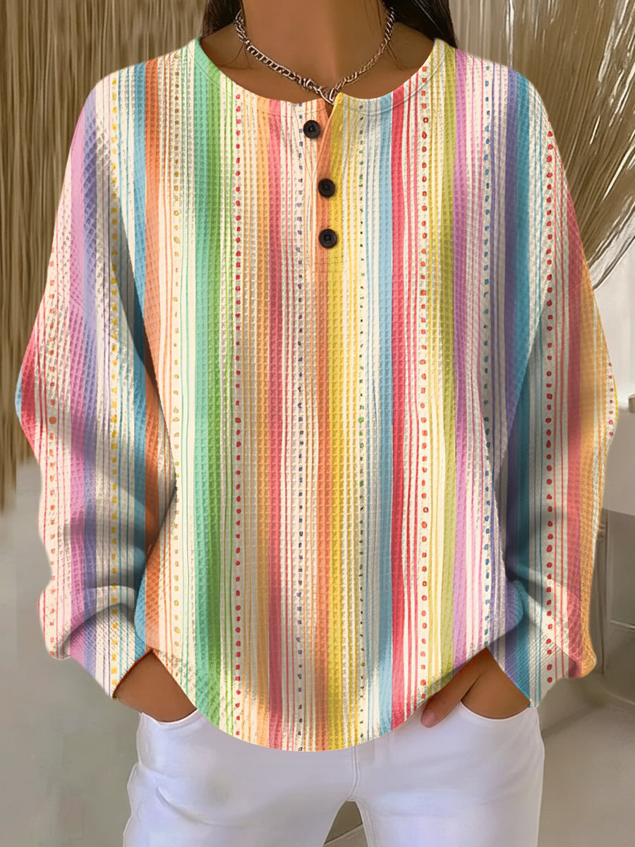 Waffle knit henley with vertical rainbow stripes and dotted lines in pastel shades, worn by a model 10