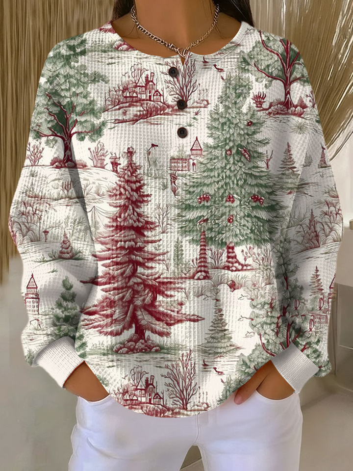 Cream waffle knit henley sweater with green and red winter forest print of pine trees and cottages, worn by a model 22