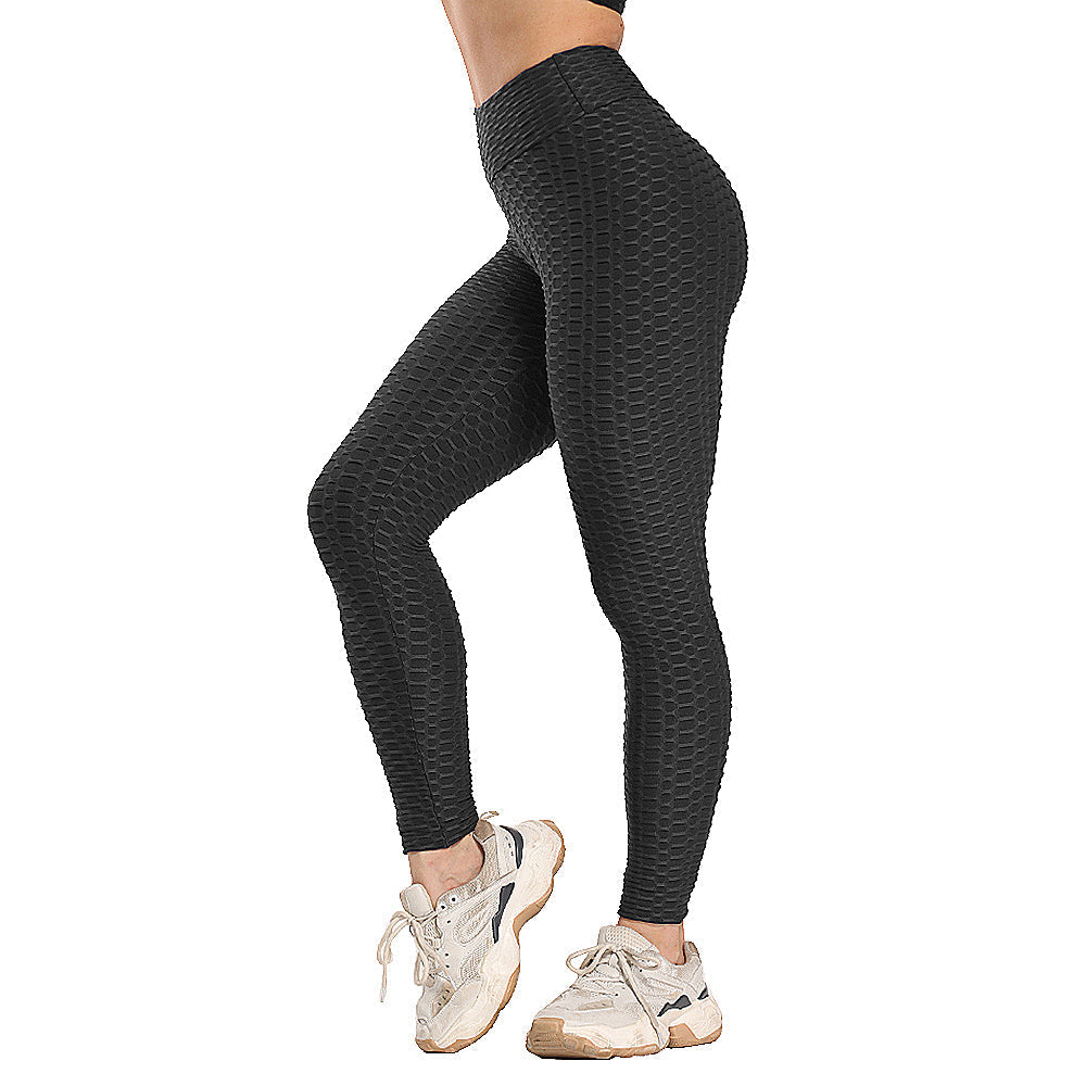 Frau in schwarzen, texturierten Leggings und weißen Sneakers, Sportbekleidung, Fitnessmode.