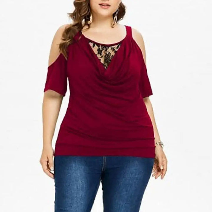 Frau in rotem Cold-Shoulder-Top mit Spitzenbesatz, kombiniert mit blauer Jeans.