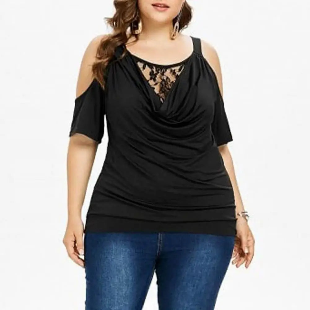 Frau in schwarzer Cold-Shoulder-Bluse mit Spitze, Plus-Size, kombiniert mit blauer Jeans.