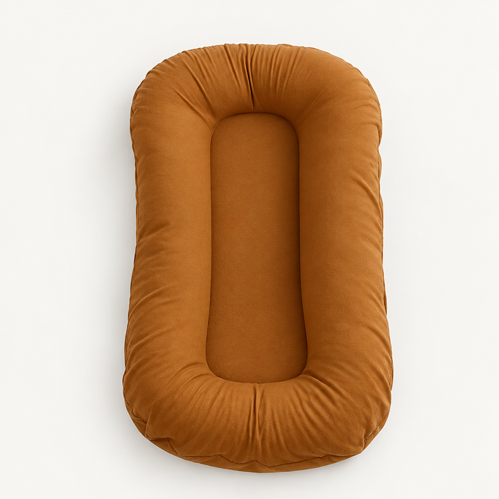 Empty rust-orange pillow seen from above, showing the thick padded rim around the center 9