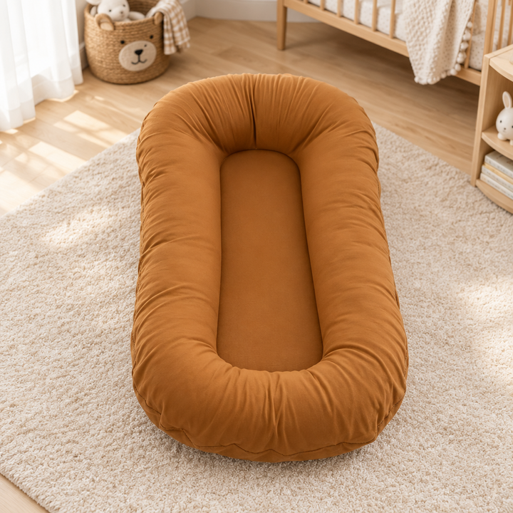 Empty caramel-brown cushion with raised edges on a nursery rug near a crib and toy basket 9