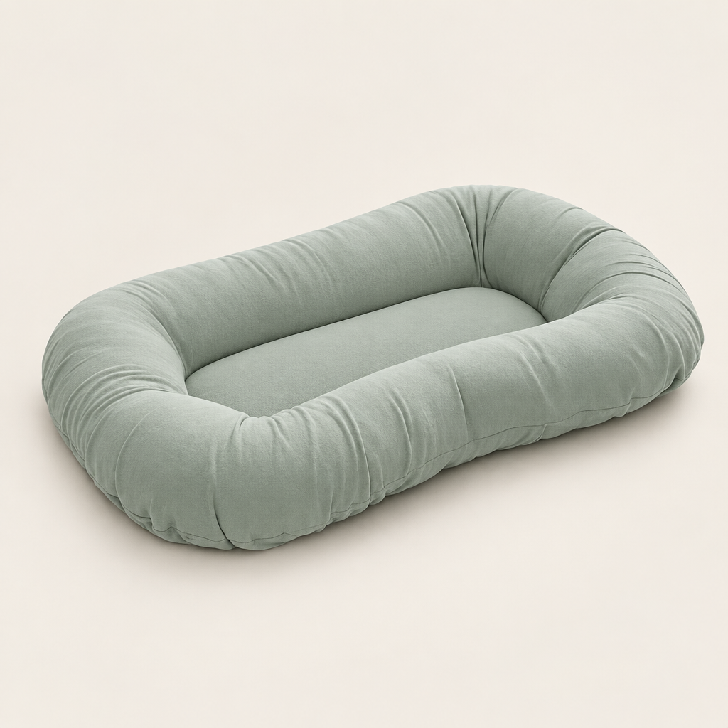 Empty sage green support pillow with a raised oval rim, shown at an angle on a cream background 8
