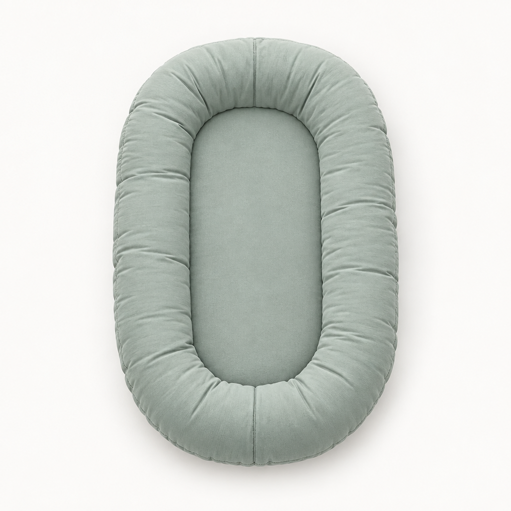 Empty sage-green oval pillow seen from above, showing the padded rim and flat center 8