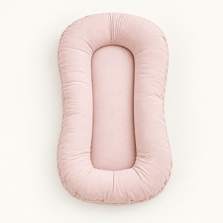 Empty blush-pink pillow seen from above, showing its soft rounded rim and flat center 10