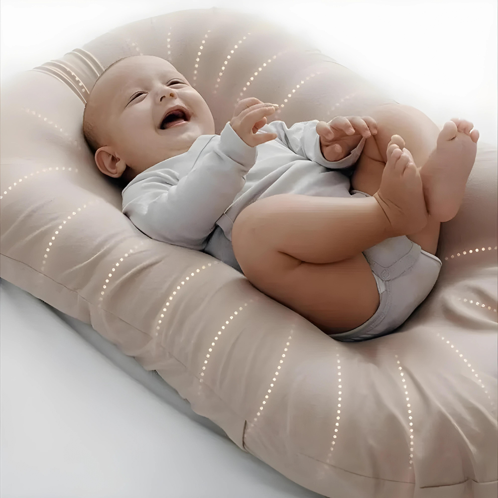 Close-up of a laughing baby grabbing its feet on a beige pillow with dotted stitching 2