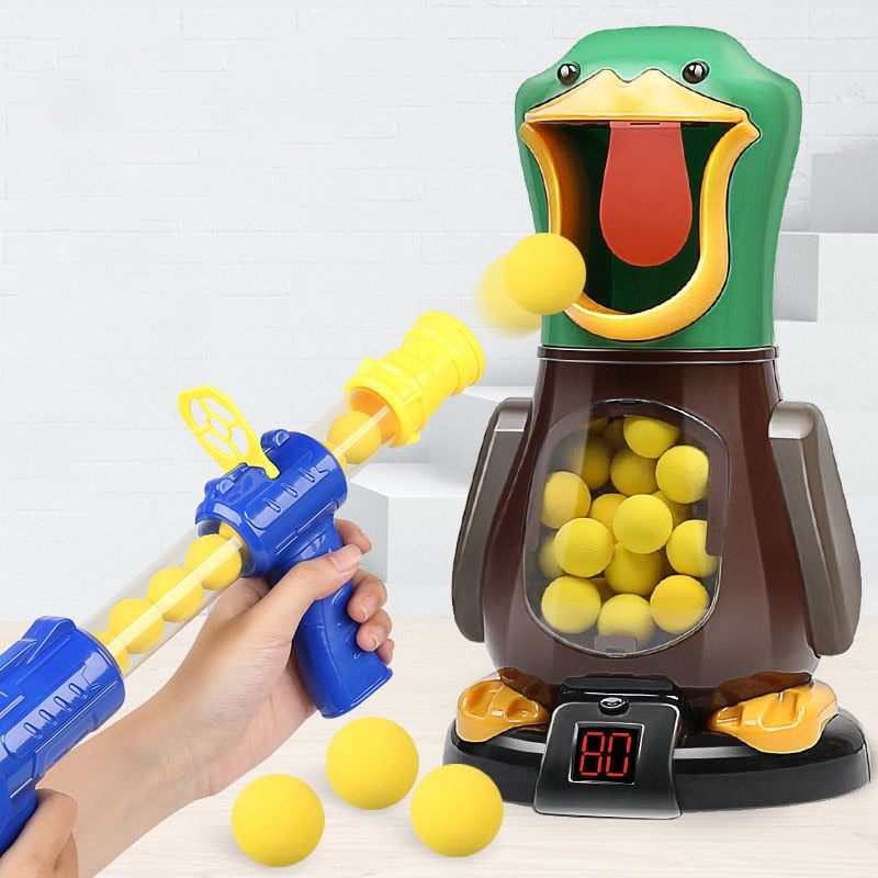 Hand holding a blaster fires a yellow foam ball into the green duck's open mouth 3