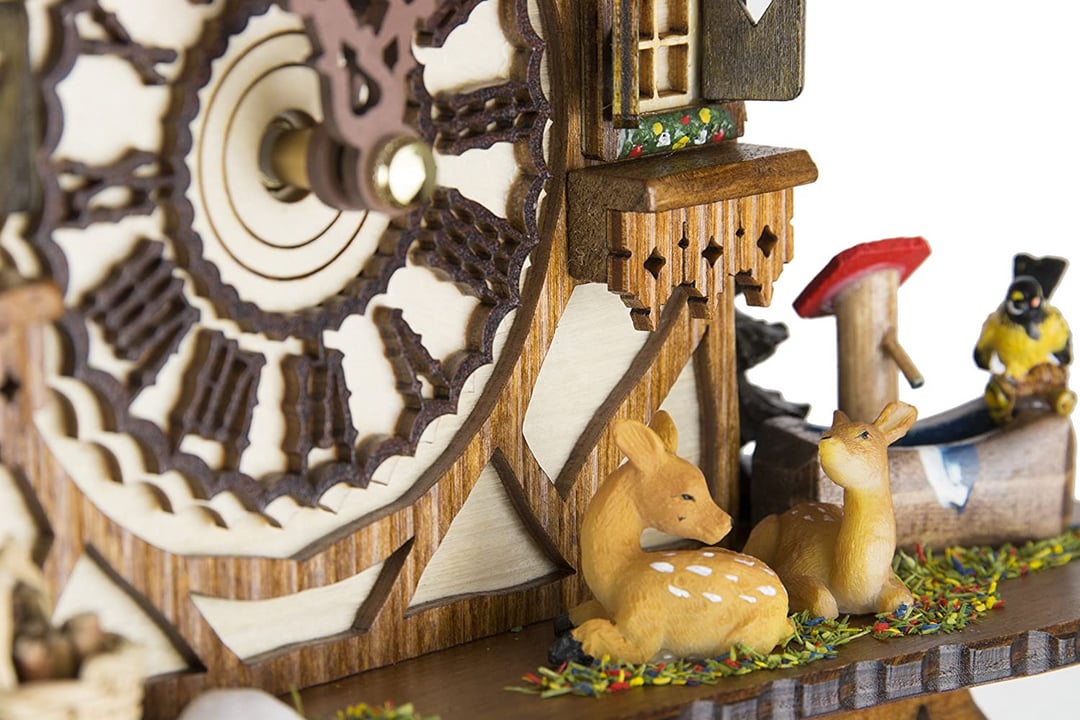 Close-up detail of two fawns, a yellow songbird, a red toadstool and the carved dial edge 15