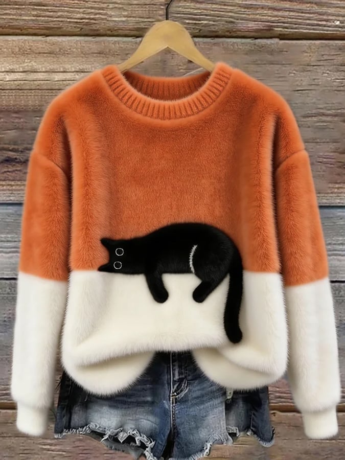 Orange and white fuzzy colorblock sweater featuring a sprawled black cat, displayed on a hanger over denim shorts. 4