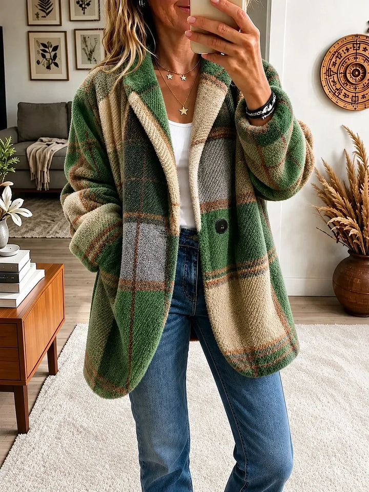 Woman wearing the textured plaid coat in a green, beige and gray colorway, open over a white top and jeans.