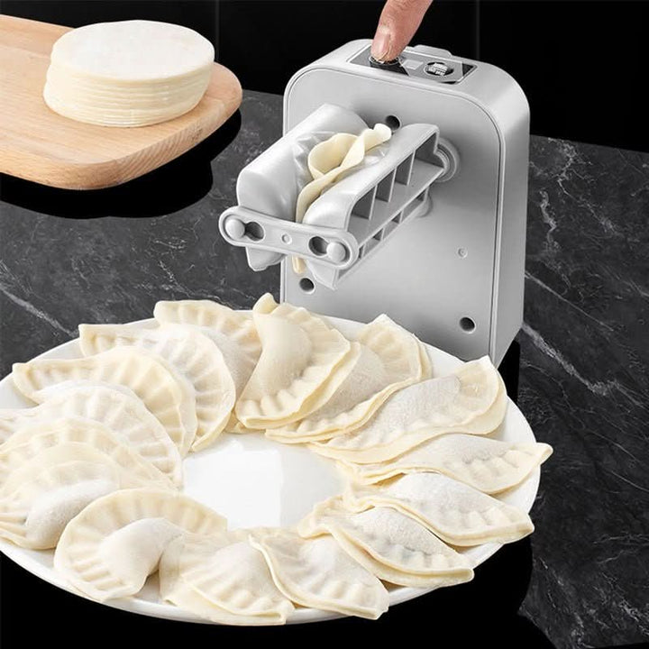 The machine's rollers pressing a dumpling closed, with a ring of finished pleated dumplings on a white plate and a stack of dough rounds on a board. 3
