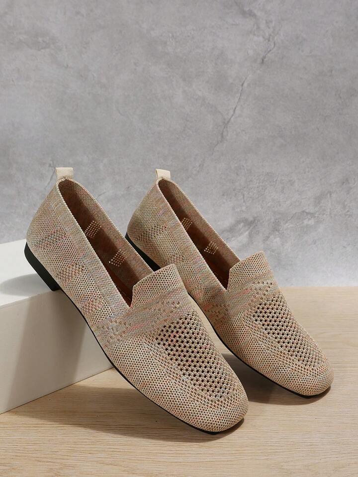 Pair of beige knit slip-ons with open mesh toes and heel tabs.