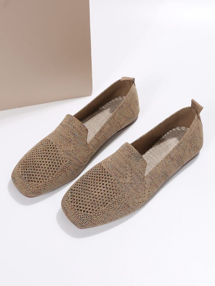 Pair of brown knit slip-on flats showing the open mesh toes and light woven insole.